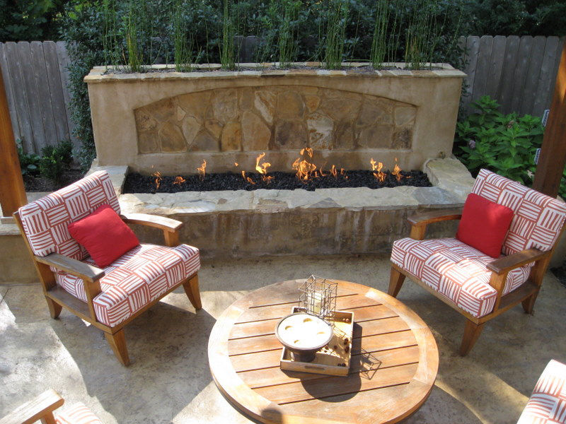 Cozy hardscape elements showing a fire pit stone wall on patio.