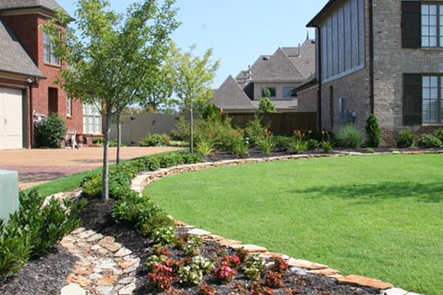 Landscaped beds with a natural stone border.