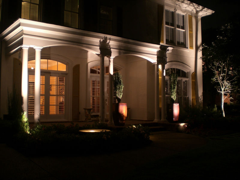 Front of home with landscape night lighting features.