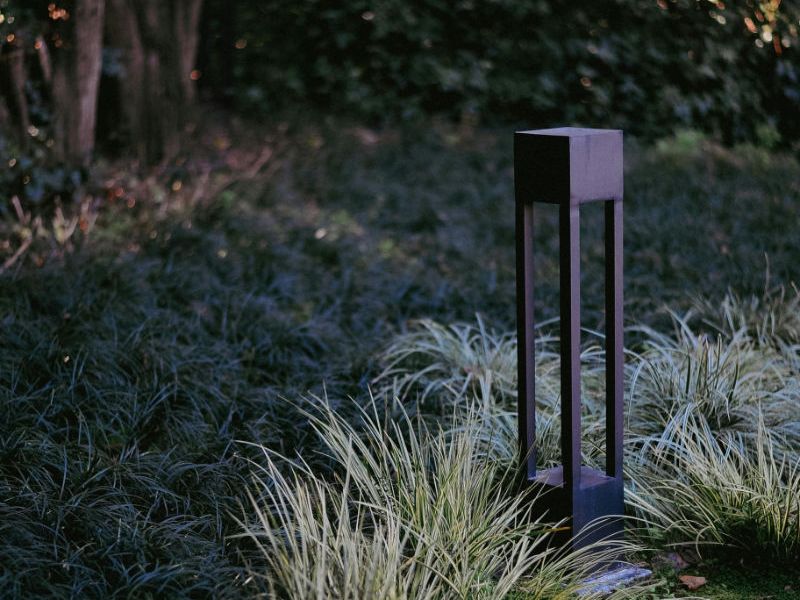 Landscape lighting box in flower bed.
