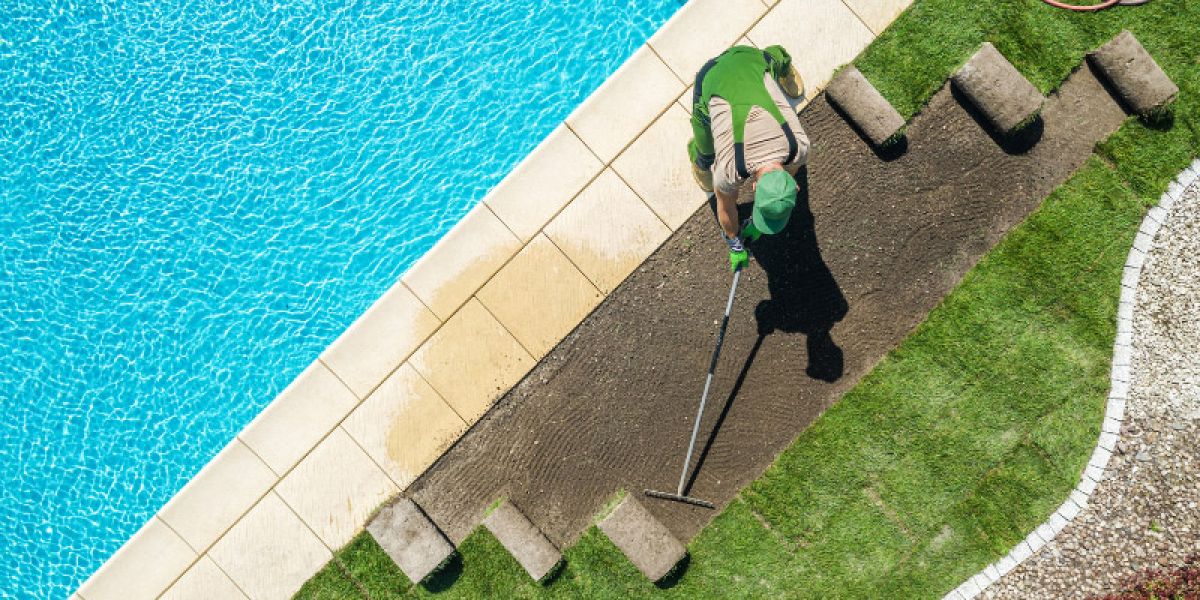 Person landscaping around an in-ground pool.